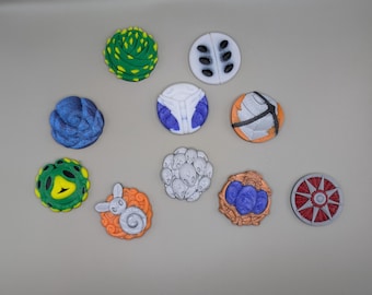 Può includere: Una collezione di 10 piccole piastrelle di ceramica rotonde dipinte con vari disegni. Le piastrelle presentano una varietà di colori, tra cui blu, verde, bianco, arancione e rosso. Alcuni dei disegni includono un teschio, un fiore, un uccello e uno schema geometrico.