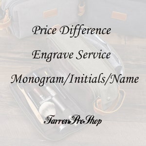 May include: A gray toiletry bag with a brown leather strap and zipper. The bag is open and contains various toiletries, including a toothbrush, razor, and shaving brush. The text "Price Difference", "Engrave Service", "Monogram/Initials/Name", and "Tarren Pro Shop" is visible on the image.