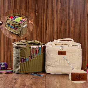 Può includere: Sono esposte due borse per l'artigianato. Una è verde oliva con tasche per uncinetti. L'altra è color crema con un'etichetta in pelle con le iniziali "BC". Le borse sono su una superficie di legno.