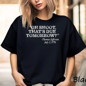 May include: Black t-shirt with a white graphic print that reads "OH SHOOT, THAT'S DUE TOMORROW?" -Thomas Jefferson July 3, 1776