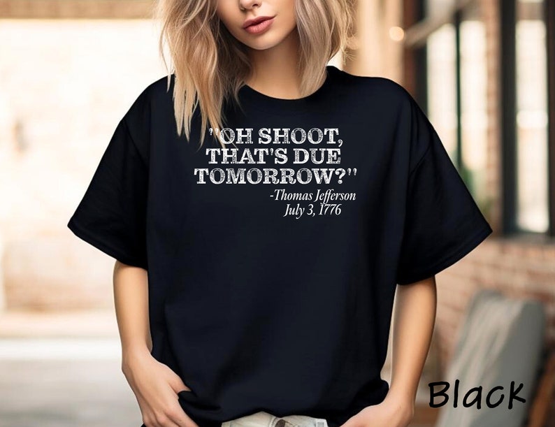 May include: Black t-shirt with a white graphic print that reads "OH SHOOT, THAT'S DUE TOMORROW?" -Thomas Jefferson July 3, 1776