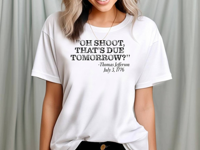 May include: White t-shirt with a black graphic print that reads "OH SHOOT, THAT'S DUE TOMORROW?" -Thomas Jefferson July 3, 1776