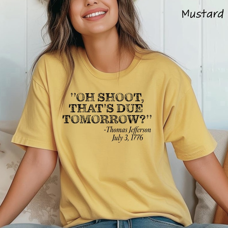 May include: A yellow t-shirt with the text "OH SHOOT, THAT'S DUE TOMORROW?" and "Thomas Jefferson July 3, 1776" printed on it.