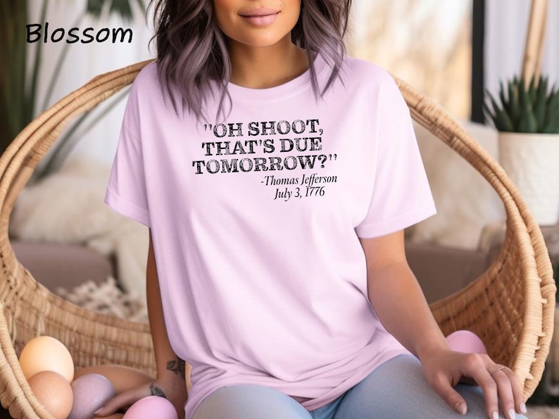 May include: A pink t-shirt with a black graphic print that reads "OH SHOOT, THAT'S DUE TOMORROW?" -Thomas Jefferson July 3, 1776.