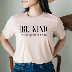 May include: A pink t-shirt with the text "BE KIND it's really not that hard" printed on the front.