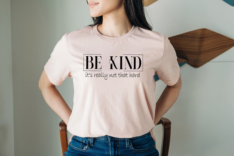 May include: A pink t-shirt with the text "BE KIND it's really not that hard" printed on the front.