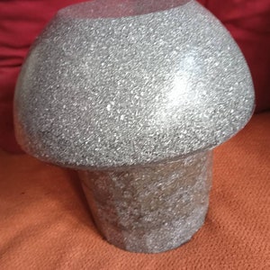 May include: A gray, textured, round lampshade with a matching base. The lampshade is made of a material that resembles a textured, speckled surface.