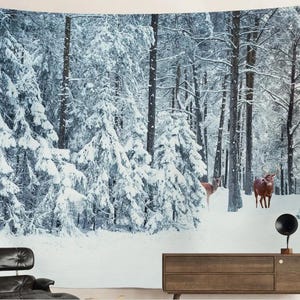 Può includere: Un arazzo da parete raffigurante una scena di foresta innevata con alberi alti e due cervi. Gli alberi sono coperti di neve, creando un paesaggio invernale. I cervi sono marroni e stanno nella neve.