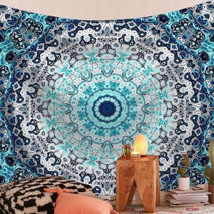 May include: A large, blue and white mandala tapestry with a detailed, symmetrical design. The tapestry features shades of blue and white in a swirling, abstract pattern. The central design is a deep blue circle.