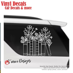 May include: A white vinyl decal featuring a line art illustration of a row of books with a bouquet of various flowers emerging from the top. The decal is applied to the rear window of a vehicle. Text includes Vinyl Decals Car Decals & more.