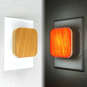 May include: A wooden night light plugged into an electrical outlet. The light is off in the left image and on in the right image, illuminating the wood with a warm orange glow.