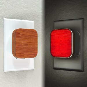 May include: A wooden night light plugged into an electrical outlet. The light is off in the first image and on in the second image, showing a red glow.