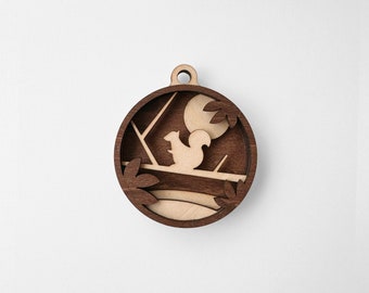 May include: A wooden ornament featuring a squirrel sitting on a branch with a moon in the background. The ornament is brown with a light wood finish and has a cutout design.