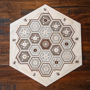 May include: A wooden hexagonal game board with a honeycomb pattern. The board has numbers 1 through 12 around the edge and a sun in the center.