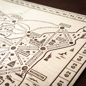 Pode incluir: Um mapa de madeira detalhado com as principais cidades da América do Norte, como Nova York, Boston e Washington, D.C., conectadas por linhas. O mapa inclui nomes de cidades e ícones que representam pontos de referência. Os números correm ao longo da borda direita.