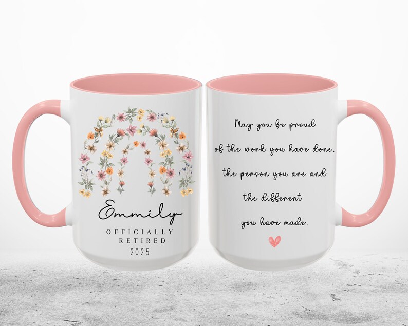 Peut inclure: Une tasse &agrave; caf&eacute; rose et blanche avec un motif floral et le texte "Emmily Officially Retired 2025". L'autre c&ocirc;t&eacute; de la tasse a le texte "May you be proud of the work you have done, the person you are and the difference you have made."