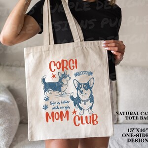 Puede incluir: Bolso tote de lona natural con un dise&ntilde;o de una cara con dos corgis ilustrados, huellas de patas y las palabras "CORGI MOM CLUB". La bolsa mide 38 cm x 41 cm.