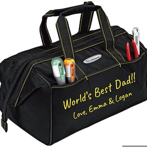 May include: Black tool bag with yellow stitching and a zipper. The bag has multiple pockets and a label that reads "Voyager". The bag has the text "World's Best Dad!! Love, Emma & Logan" written on the front in yellow.
