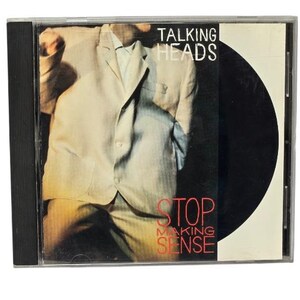 May include: A Talking Heads Stop Making Sense music CD in a clear plastic jewel case. The cover art features a person wearing an oversized light-colored suit jacket, with the band name and album title printed in white and red text on a black background.