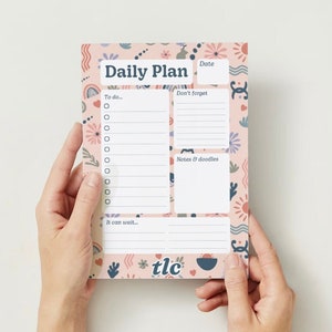 May include: A pink daily planner with a floral pattern. The planner has sections for "To do", "Don't forget", "Notes & doodles", and "It can wait".