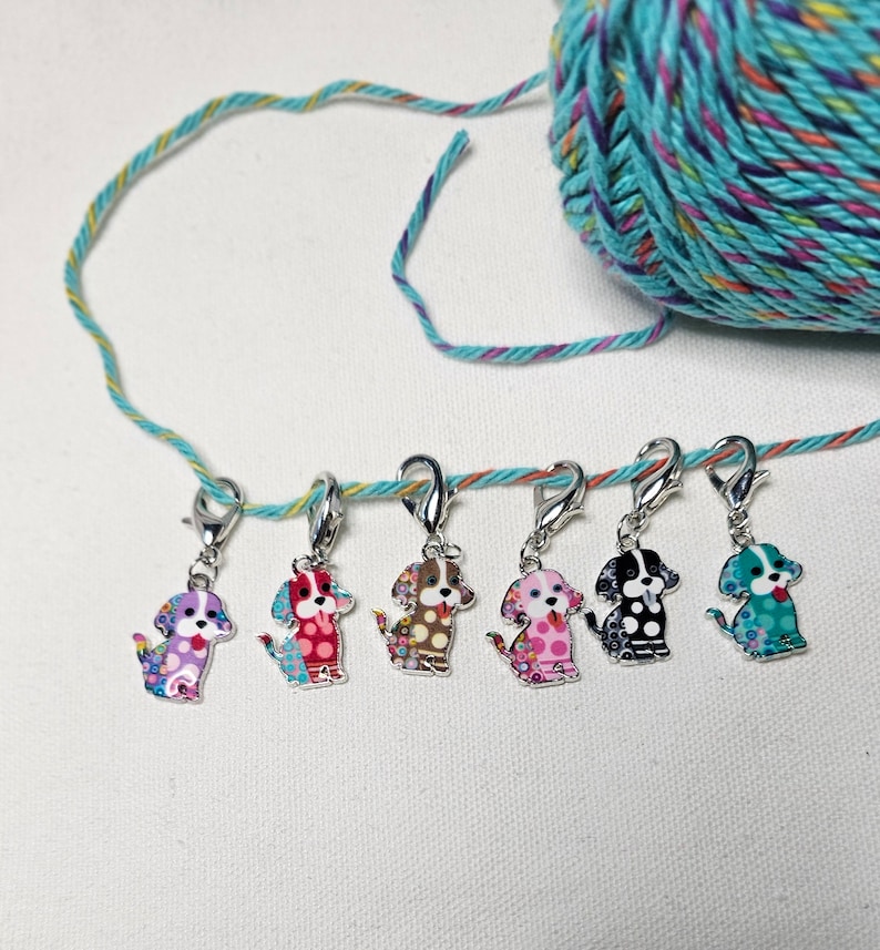 Pu&ograve; includere: Sei marcapunti a forma di cane colorati con chiusure argentate. I marcapunti sono appesi a un filo turchese e giallo.