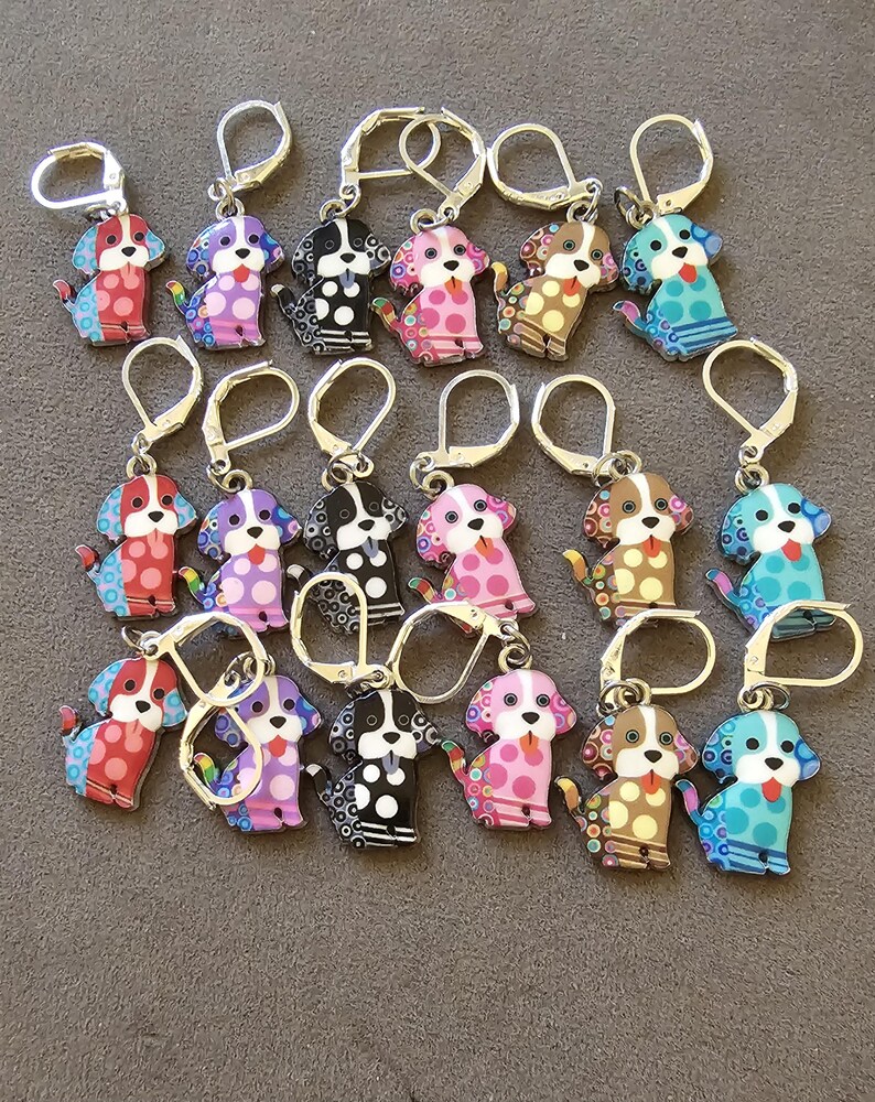 Enameled Dog Stitch Markers with a ring styled clasp for knitters mostly.  They may also be used as earrings.  The clasps are silver in color but look more gold in the photo. There is a lot of detail in each dog and  they are very cute and happy.