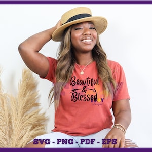 May include: A woman wearing a red t-shirt with the text "Beautiful & Blessed" in black lettering. She is wearing a straw hat and has long brown hair.