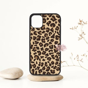 May include: A black phone case with a leopard print design. The case has a cutout for the camera lens.