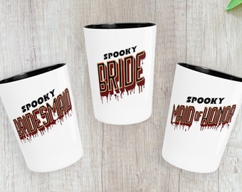 May include: Three white ceramic mugs with black rims. The mugs have a spooky theme with the text "Spooky Bride", "Spooky Bridesmaid", and "Spooky Maid of Honour" in red and gold dripping letters.