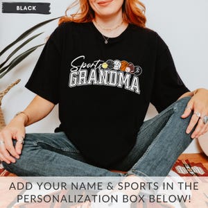 May include: Black t-shirt with the text "Sports Grandma" and a row of sports balls printed on the front.