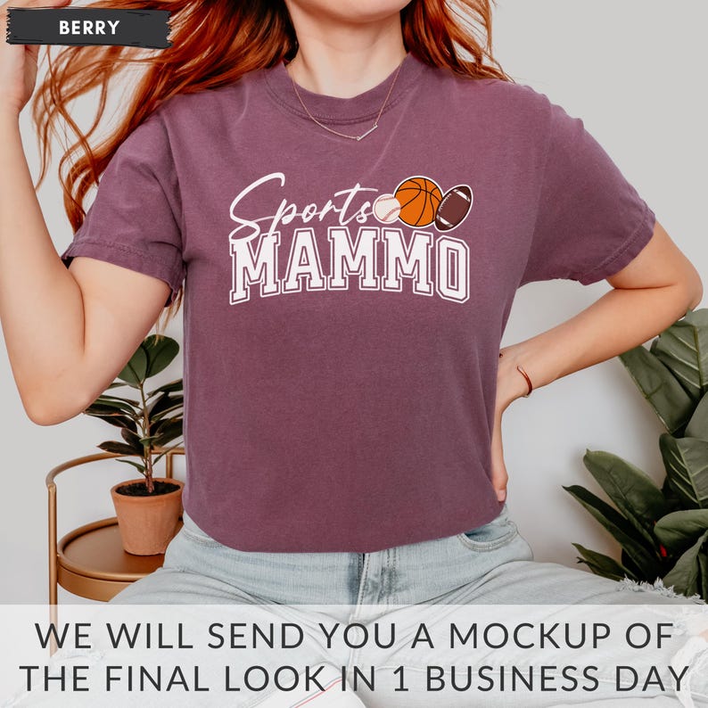 May include: A purple t-shirt with the text "Sports Mammo" in white lettering. The shirt has a graphic of a baseball, basketball, and football.