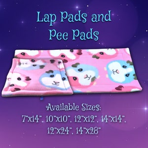 May include: Pink lap pads and pee pads with a repeating pattern of guinea pig faces in blue, pink, and white. The pads are available in various sizes, including 7"x14", 10"x10", 12"x12", 14"x14", 12"x24", and 14"x28". The text "Lap Pads and Pee Pads" is displayed at the top.