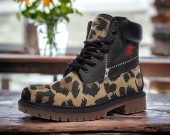 May include: Brown leather boots with a leopard print design and a black skull and crossbones graphic on the side. The boots have a brown rubber sole.