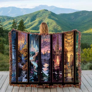 Könnte beinhalten: Eine gewebte Decke mit einer Reihe vertikaler Tafeln, die jeweils eine Fantasy-Landschaft zeigen. Die Tafeln haben unten Text und Fransen an den Rändern. Die Decke wird vor dem Hintergrund grüner Hügel und Berge präsentiert.