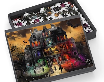 May include: A jigsaw puzzle featuring a spooky haunted house scene with bats, figures, and an orange sky. The puzzle is in a black box, with some pieces scattered in the lid. The house has multiple lit windows and a detailed facade.