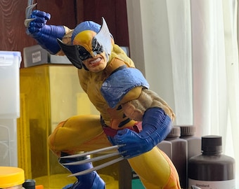 May include: A yellow and blue action figure of Wolverine, a superhero from Marvel Comics, with claws extended, standing on a rocky base. The figure is posed in a dynamic action stance.