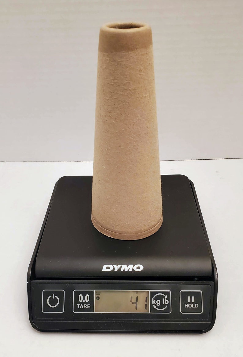 May include: A brown paper cone on a black digital scale that reads 4.1 kg or 9.0 lb. The scale has a tare button, a kg/lb button, and a hold button.