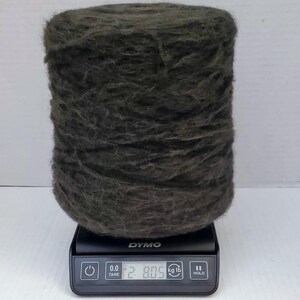 May include: A large spool of dark green yarn is sitting on a digital scale. The scale reads 2.805 kg or 6.19 lb.