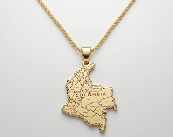 May include: A gold-toned necklace featuring a pendant shaped like the map of Colombia. The pendant includes engraved lines representing the country's departments and the text COLOMBIA centered on the surface. The pendant hangs from a gold chain.