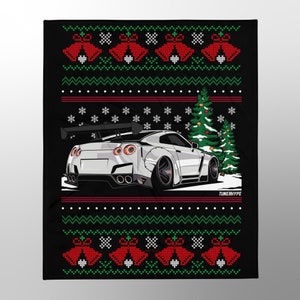 May include: Black blanket with a Christmas sweater design. The design features a white sports car, Christmas trees, snowflakes, and red bells. The text "TUNERHYPE" is visible at the bottom right.