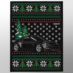 May include: Black blanket with a Christmas sweater design. Features a black sports car, Christmas trees, snowflakes, and the text "TUNERHYPE". The blanket has a festive pattern with green, red, and white accents.