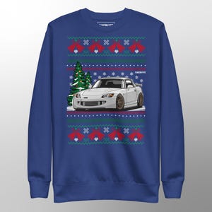 Könnte beinhalten: Blaues Sweatshirt mit einem weißen Sportwagen-Design, Weihnachtsbaum und roten Glocken-Akzenten. Der Text "TUNE/TYPE" ist sichtbar. Das Sweatshirt hat einen Rundhalsausschnitt und lange Ärmel.