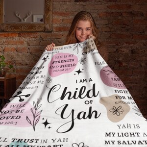 May include: White throw blanket with pink and beige circles and floral designs. The blanket features inspirational text with bible verses, including "I am a Child of Yah" and "Yah is my strength and shield".