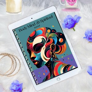 May include: A white tablet computer with a blue and purple cover. The cover features an abstract design of a woman's face with colorful swirls and circles. The text "Body Mind & Spiritual Journal" is printed on the cover.