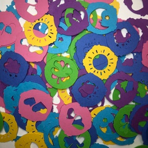 May include: Assortment of colorful paper cutouts in various shapes, including circles, stars, and leaves. The cutouts are made of a thin, lightweight paper and have a delicate, intricate design.
