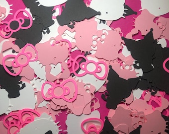 May include: A collection of pink and black paper cutouts of Hello Kitty characters. The cutouts are in various shapes and sizes, including Hello Kitty's face, her bow, and her silhouette.