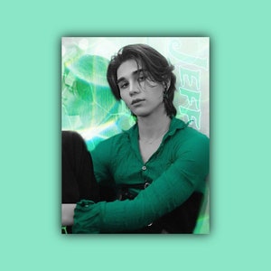 May include: A portrait of a person with dark hair wearing a green shirt with a black belt. The background is a blurry green and white pattern with the word "JEFFE" written in white.