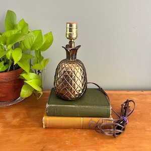 Lámpara de mesa vintage de latón macizo con forma de piña y detalles dorados estilo Hollywood Regency.