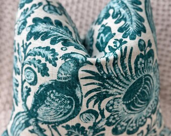 May include: Teal blue and white patterned throw pillow with a floral and bird design.