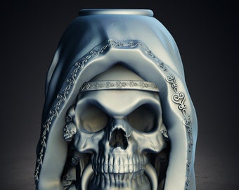 May include: A silver-colored skull sculpture with a draped hood. The skull has large eye sockets, a prominent jaw, and decorative elements around the hood and base. The sculpture has a detailed, gothic design.